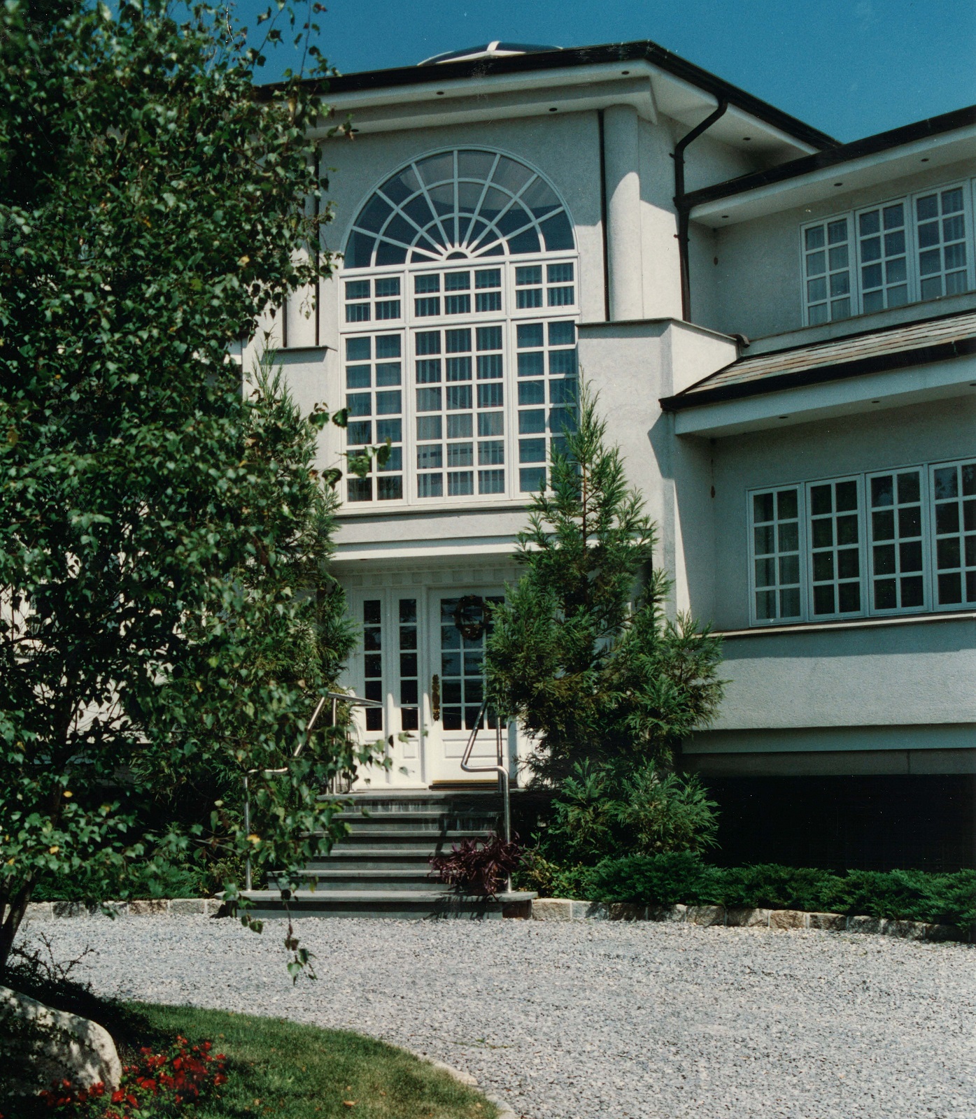 Residential design of front entry after renovation. Visual impact of the unusual overall height into first floor was mitigated by splitting the transition between exterior and interior stairs.