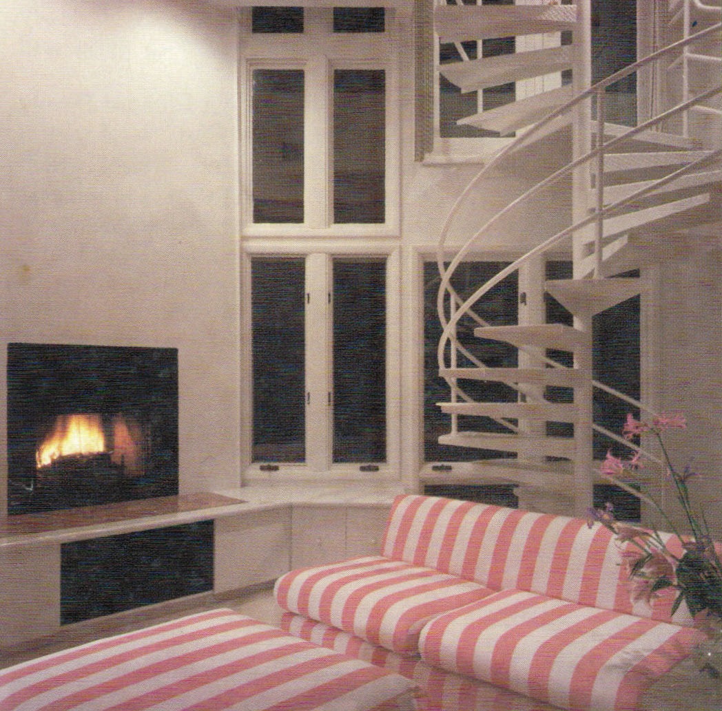 Renovated living room with new fireplace and circular stair to added second floor.
