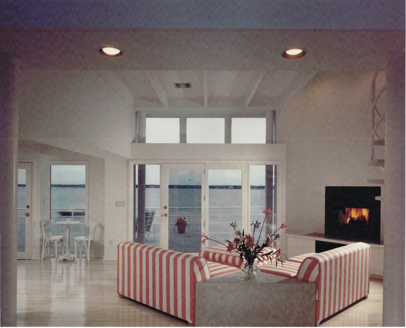 Water view through glass of renovated living room with added glass transom.